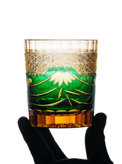 Green Mt. Fuji patterned glass held in a black-gloved hand